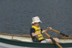 Boy trying out a rowboat at the Small Craft Workshop