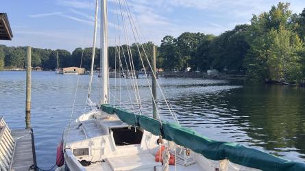 Custom Phil Bolger Wooden Triple-Keel Sloop, docked port side stern view