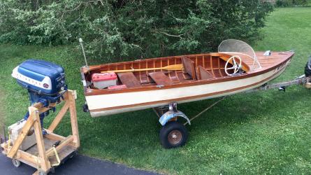 Boat built in 1958, Evinrude big twin motor, electric start, on trailer on the hard