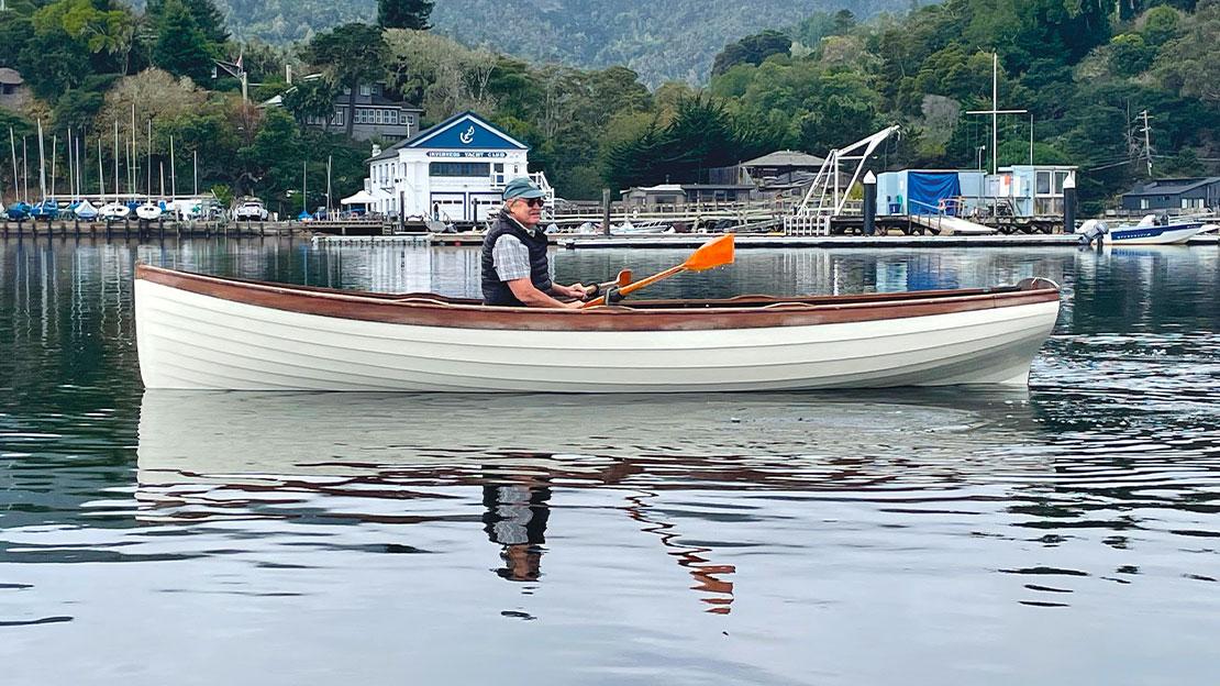 Man in a white canoe with reflection off the water.