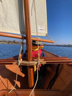 Dory under sail with small child in the bow