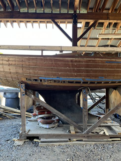 Wooden ballast keel sloop "RASCAL", on stands inside port side view, keel