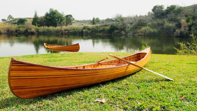 Wooden Canoe With Ribs Curved Bow 12', long view on grass with paddle
