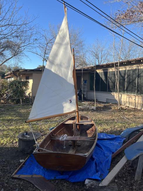 Pram for free, on the hard, sail up, stern view