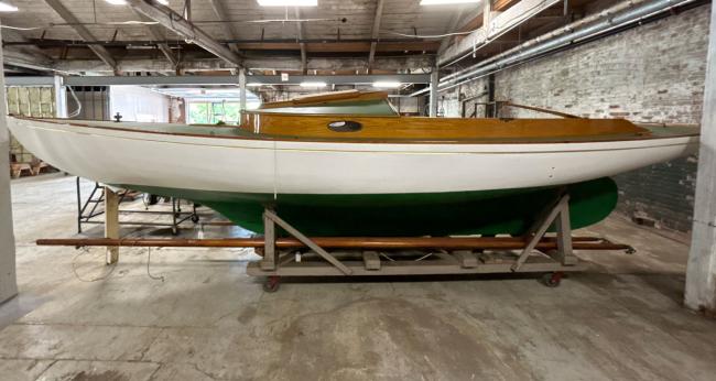 Small wooden boat in an exhibition room.