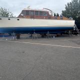 Classic wooden twin diesel cruiser, on the hard port side view